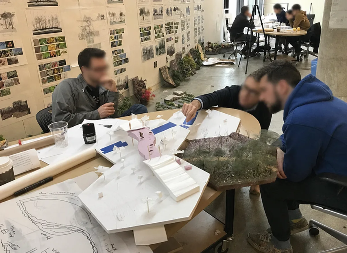 Anonymized architecture students examining design models during a studio critique